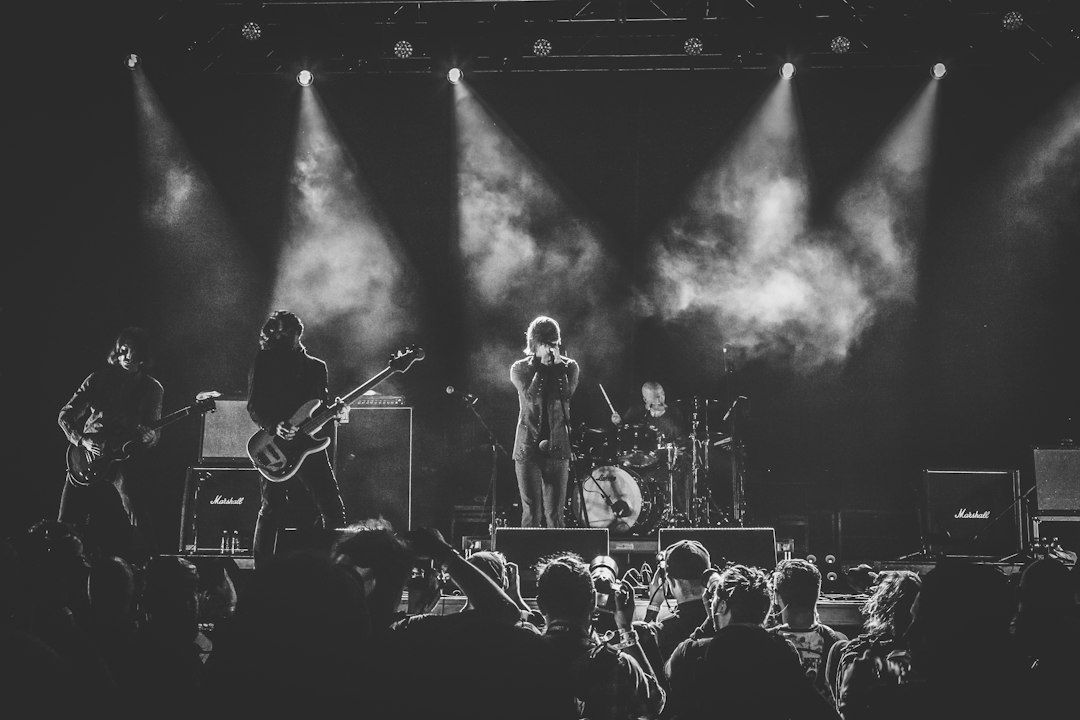 Black-and-white rock band performing under stage lights and smoke